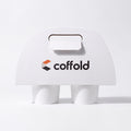 Coffold two-cup drinks carrier in white board, locking tab folded through the handle slot, holding two takeaway coffee cups